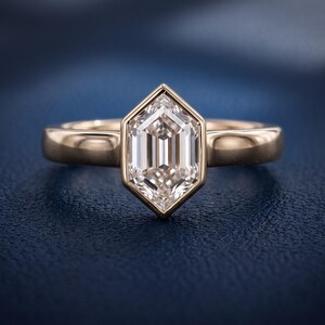 Front studio close-up of a hexagon step cut lab grown diamond solitaire engagement ring with an architectural bezel-style frame.