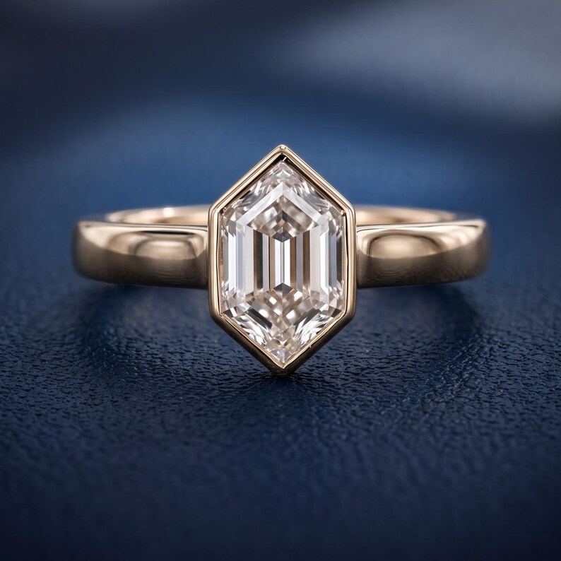 Front studio close-up of a hexagon step cut lab grown diamond solitaire engagement ring with an architectural bezel-style frame.
