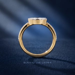 Side profile of marquise lab grown diamond engagement ring in yellow and white gold, showing bezel setting, band structure and elevated center stone design.