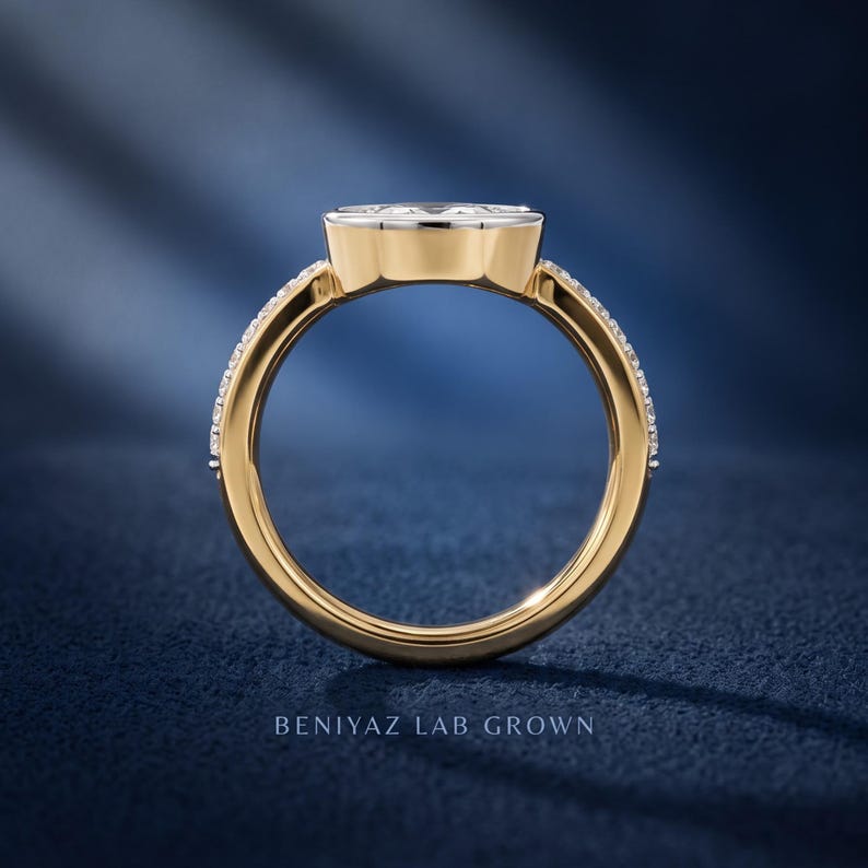 Side profile of marquise lab grown diamond engagement ring in yellow and white gold, showing bezel setting, band structure and elevated center stone design.