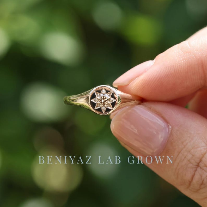 Angled view of star set diamond signet ring with single champagne lab grown diamond and minimalist tapered shank