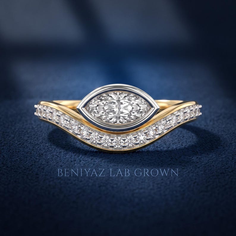 Marquise cut lab grown diamond bridal ring set with white gold bezel setting, yellow gold band and sparkling curved diamond wedding band, front close-up view.