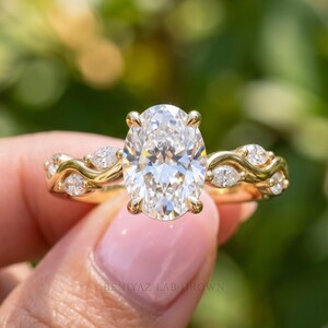Front close-up of oval lab grown diamond engagement ring with sparkling side stones and unique vintage inspired gold design.