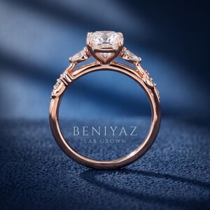 Side profile of a marquise lab grown diamond engagement ring showing the raised centre setting, rose gold band and detailed leaf inspired shoulders.