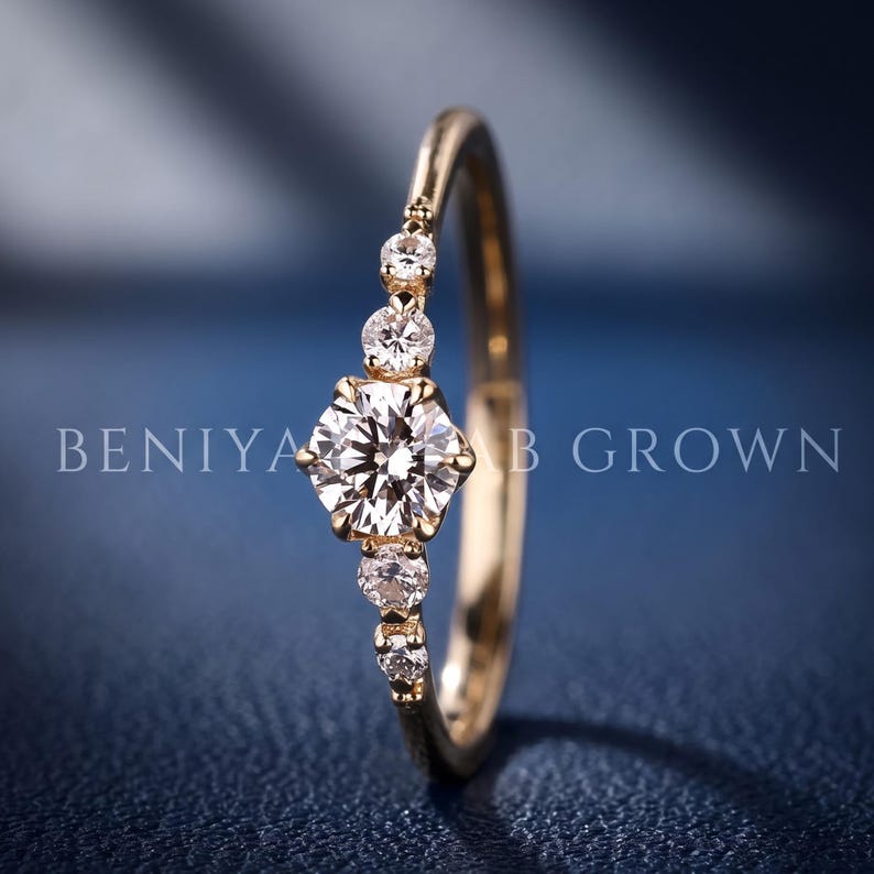 Detailed side view of a five stone lab grown diamond ring highlighting the raised centre diamond, graduated accents and open gallery design.