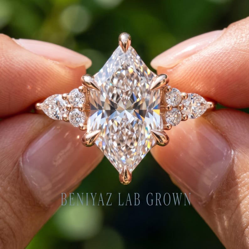 Profile view of marquise diamond engagement ring held upright showing raised prong setting and slim band