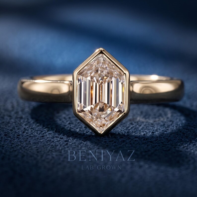 Hexagon step cut lab grown diamond engagement ring with a geometric bezel-style setting and polished solitaire band shown in a front studio view.