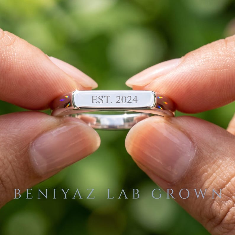 Hand holding a personalized wedding band showing custom inside engraving, polished finish and clean contemporary ring design