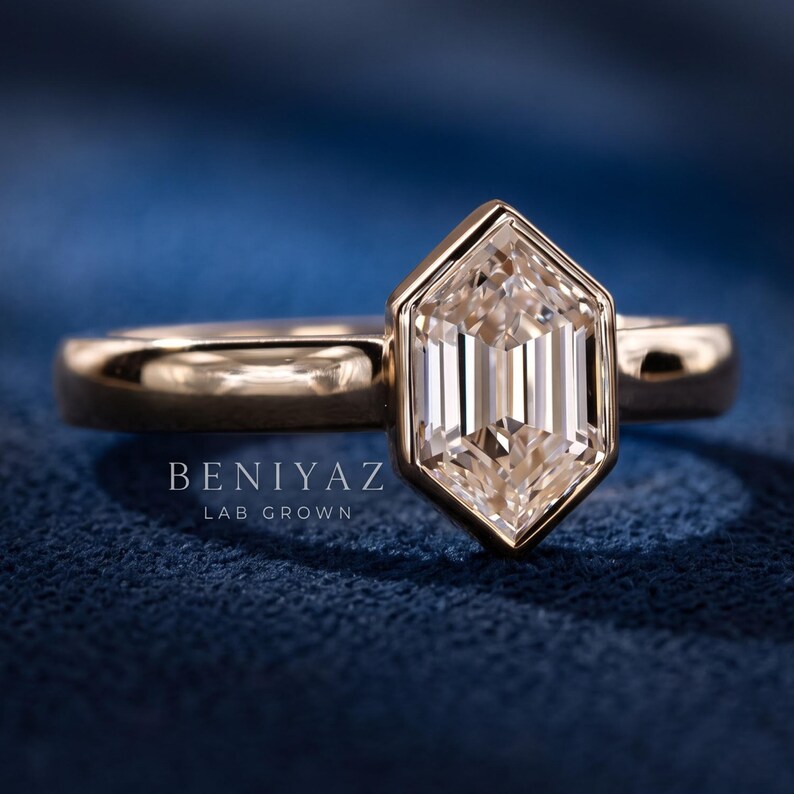 Detailed studio view of a bezel set hexagon step cut lab grown diamond ring showing the clean polished band and elongated center stone.