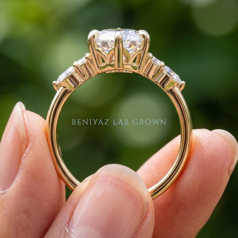Side view of marquise engagement ring on blue velvet showing elevated center setting and decorative gallery structure