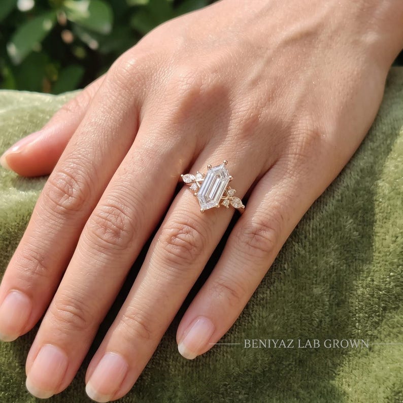 Woman wearing a 2 carat elongated hexagon lab grown diamond engagement ring with marquise and round accent diamonds