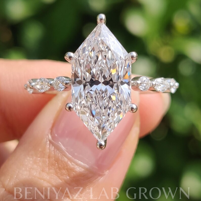 Close-up of an elongated Dutch marquise lab grown diamond engagement ring, highlighting the distinctive pointed diamond shape, polished prong setting and delicate marquise accent stones.