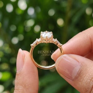 Rear view of hexagon engagement ring held by hand showing tapered shank, open setting and polished yellow gold band