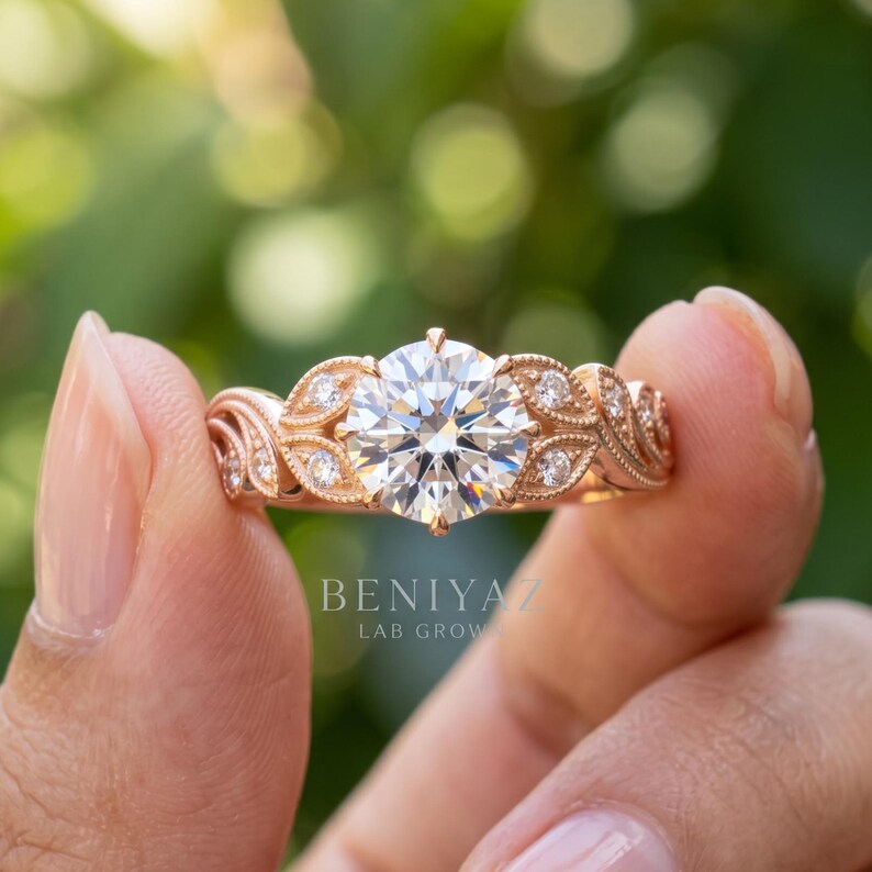 Hand displaying a round lab grown diamond engagement ring in yellow gold with a classic multi stone design and bright outdoor green backdrop