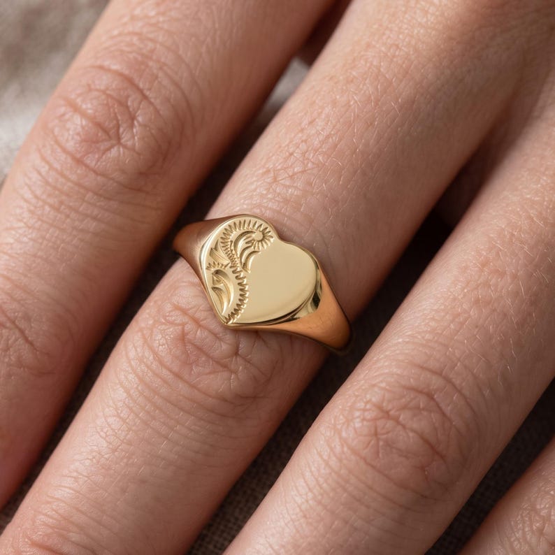 Heart shaped signet ring worn on hand, showing the smaller ladies signet face and high polish yellow gold tone finish