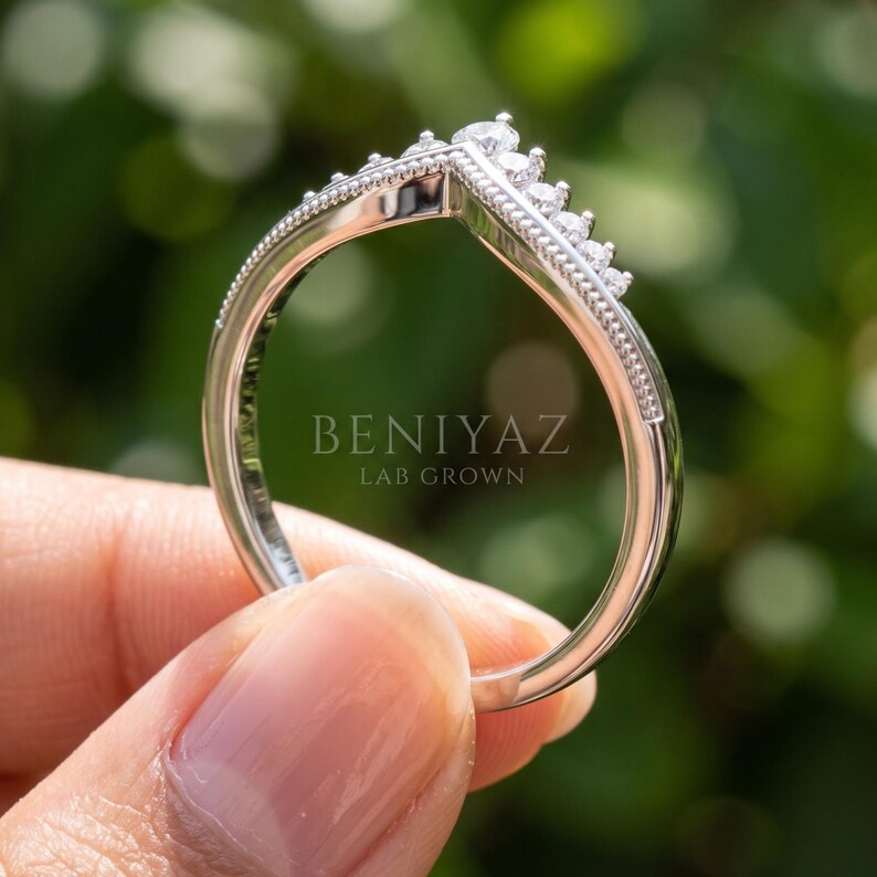 Angled full ring view of moissanite curved wedding band showing the contour shape designed for stacking with an engagement ring.