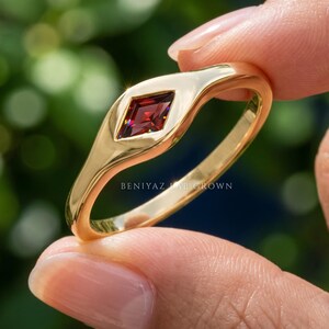 Side angle of minimal red gemstone ring with low profile flush set center stone and tapered geometric band.