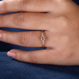 Five stone lab grown diamond promise ring worn on a woman’s hand, showing the delicate scale and minimalist thin band design.