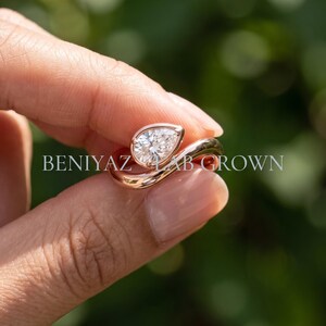 Pear lab grown diamond bypass engagement ring worn on hand, showing the scale and bold sculptural silhouette.