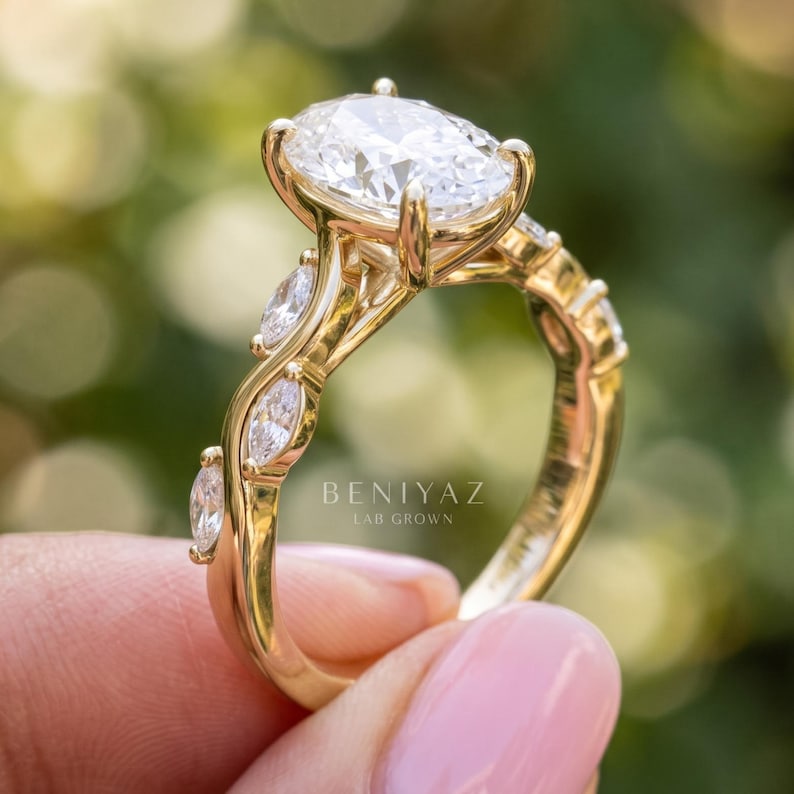 Side profile of oval engagement ring showing the raised lab grown diamond center, accent stones and dainty polished gold band.