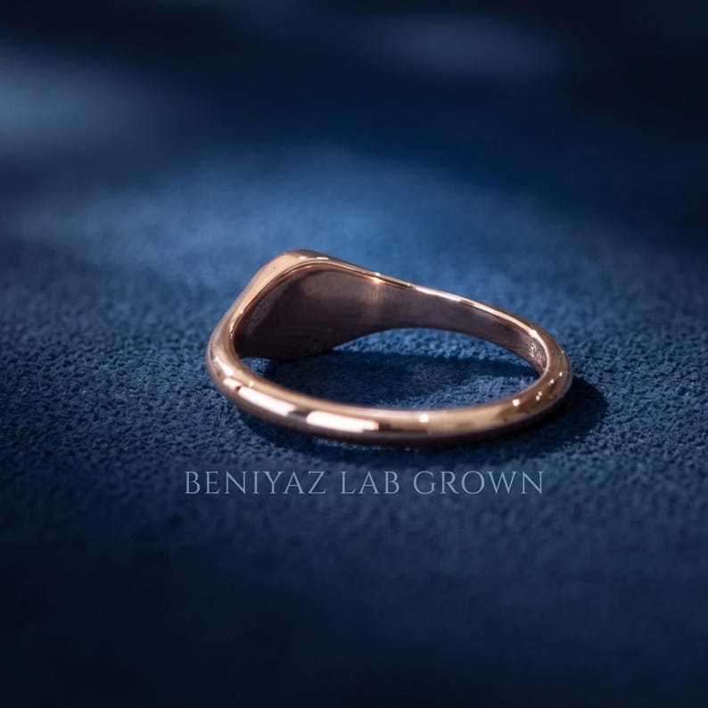 Back and inside view of rose gold tone round signet ring showing tapered band, smooth interior and stone free design