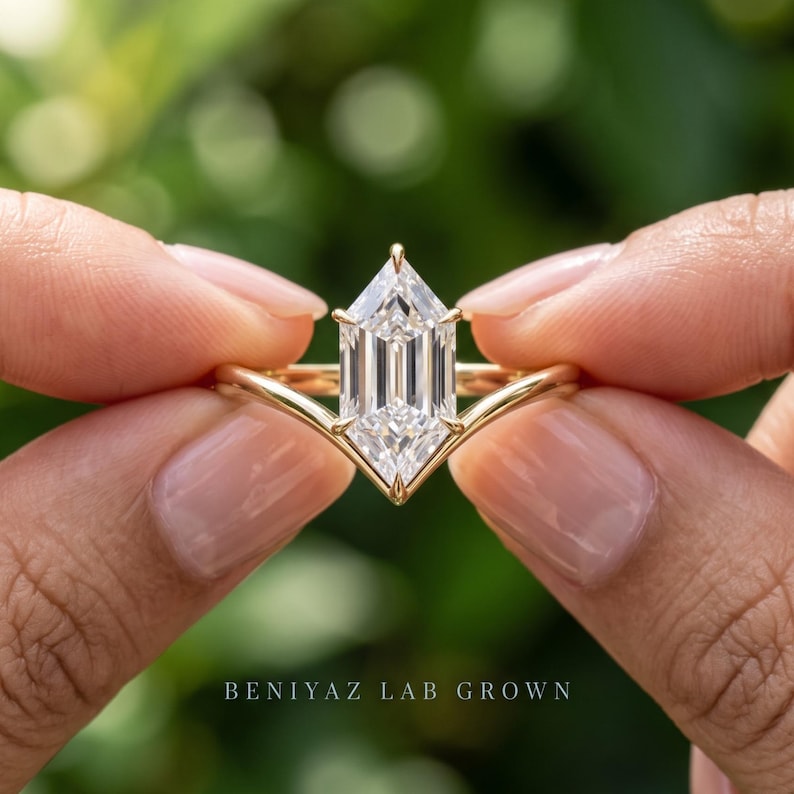 Hand held front view of a Dutch Marquise engagement ring showing the pointed center diamond and chevron solitaire design.
