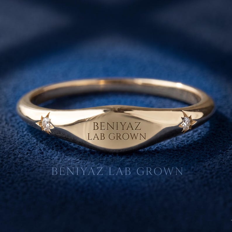 Custom engraved tapered signet ring in yellow gold showing BENIYAZ LAB GROWN text across the polished front face.