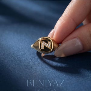 Custom initial N diamond signet ring worn on a finger, showing the elegant 14K yellow gold finish, personalized letter design and comfortable everyday fit.