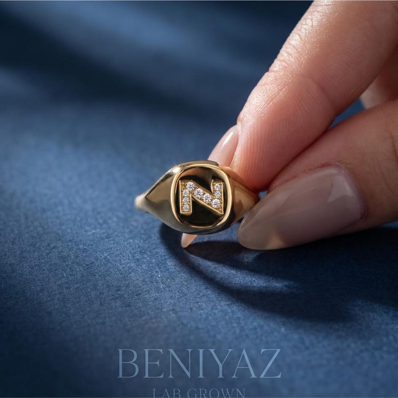 Custom initial N diamond signet ring worn on a finger, showing the elegant 14K yellow gold finish, personalized letter design and comfortable everyday fit.