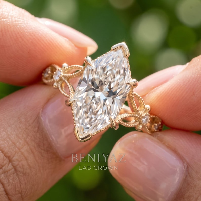 May include: A gold ring featuring a large marquise-cut center stone with a faceted surface. The band displays intricate filigree metalwork with small round accent stones embedded along the sides. The text BENIYAZ LAB GROWN is visible.