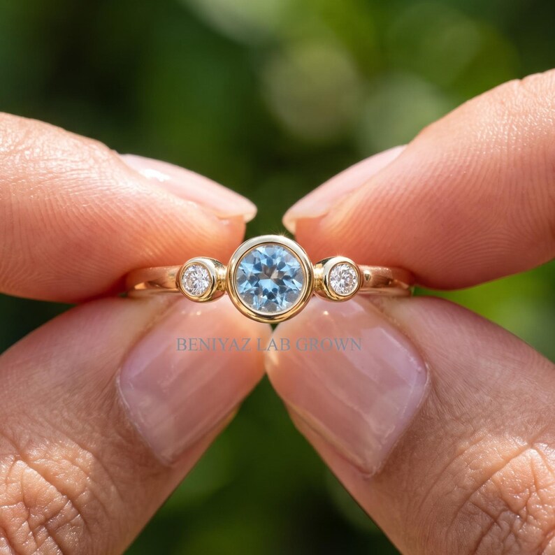 Blue gemstone three stone ring shown in yellow gold, rose gold and white gold options.