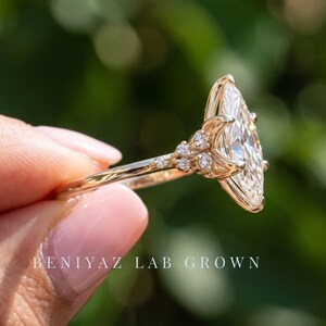 Side profile of marquise diamond ring showing the raised center setting, vintage inspired diamond cluster and hidden accent detail.