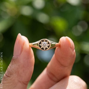 Side angle of minimalist champagne diamond signet ring showing slim tapered shoulders and round celestial signet face