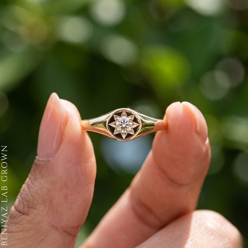 Side angle of minimalist champagne diamond signet ring showing slim tapered shoulders and round celestial signet face