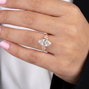 Lifestyle hand view of lab grown diamond marquise ring with sparkling side stones and romantic vintage engagement style.