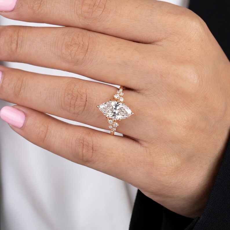 Lifestyle hand view of lab grown diamond marquise ring with sparkling side stones and romantic vintage engagement style.