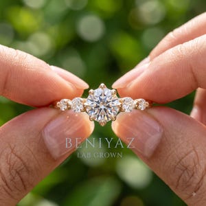 Hand wearing a dainty round lab grown diamond engagement ring in solid gold with a slim 1.9 mm band, delicate minimalist jewelry for everyday wear