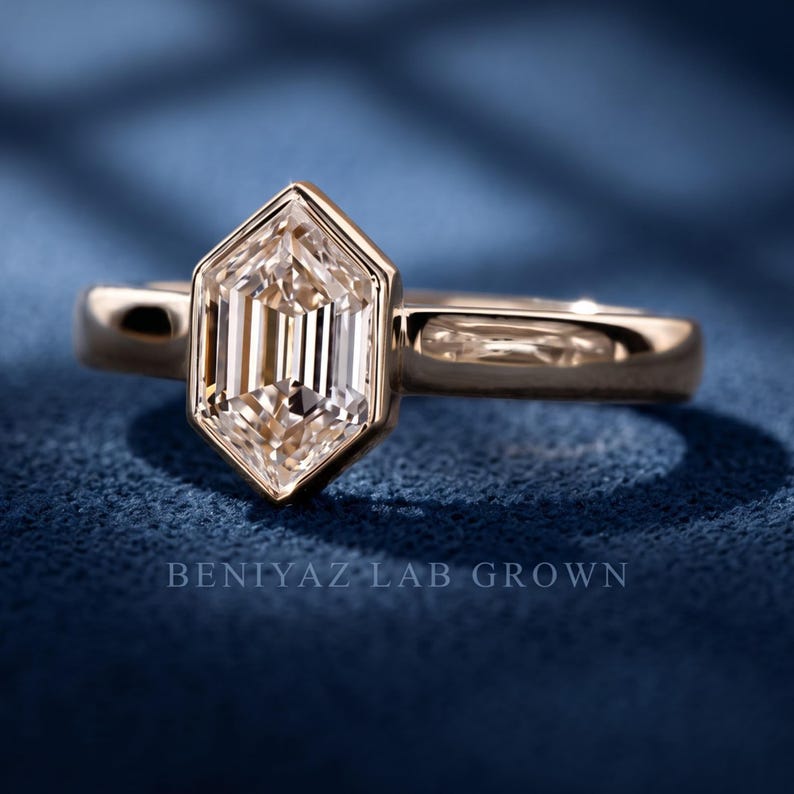 Angled studio view of a geometric hexagon lab grown diamond engagement ring featuring a step cut center stone and bezel-style setting.