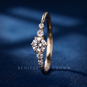 Side profile of a dainty lab grown diamond promise ring showing the raised centre setting, open gallery and slim polished yellow gold band.