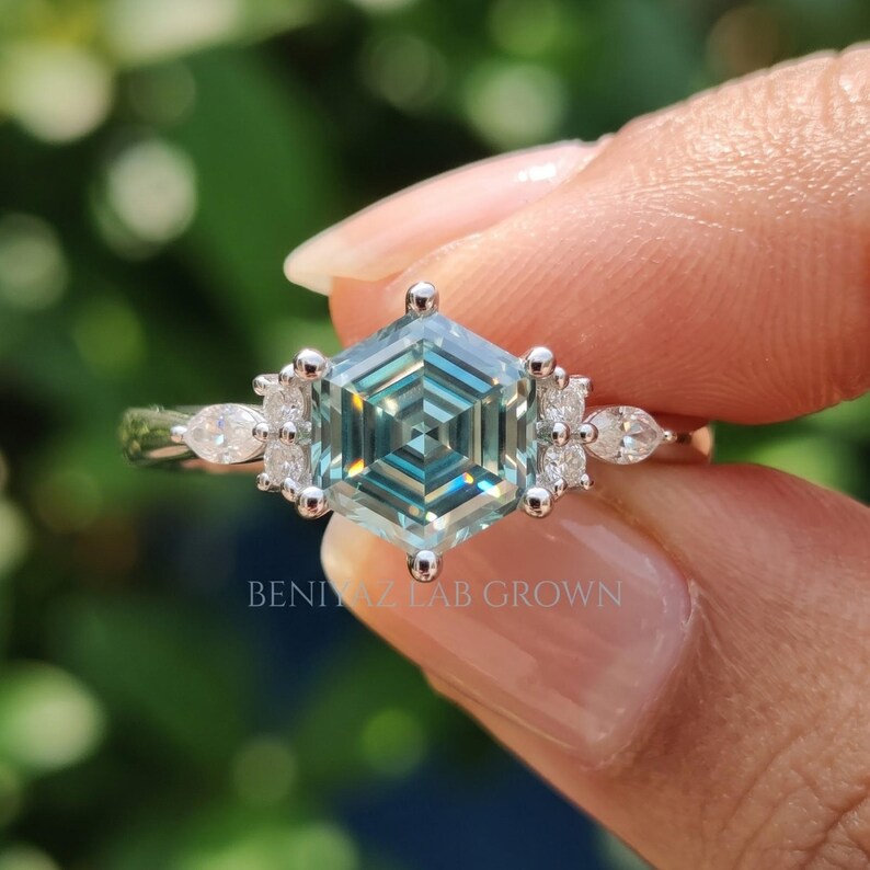 Geometric cluster engagement ring with cyan blue hexagon moissanite center and marquise round side stones for women.
