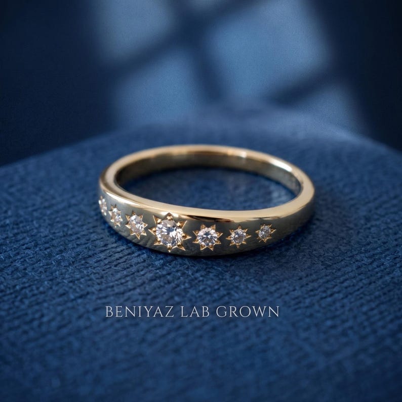 Celestial star set diamond ring displayed on blue background with seven graduated lab grown diamonds and smooth polished band