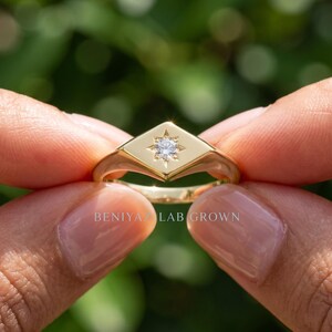 Diamond signet ring front angle featuring a 0.03 CT round cut lab grown diamond in decorative celestial star setting.