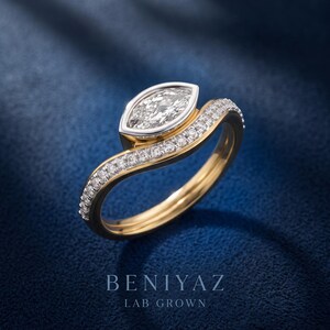 Front side view of marquise lab grown diamond engagement ring and curved wedding band, highlighting the bezel center setting and sparkling pave diamonds.