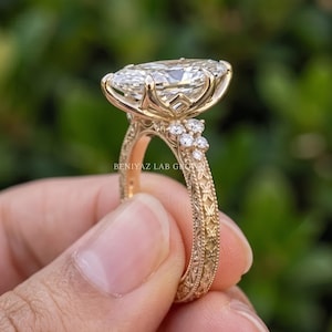 Rear view of a marquise diamond engagement ring showing the yellow gold shank, elevated centre setting and diamond shoulders.