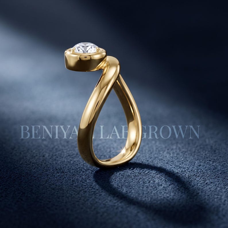 Modern pear lab grown diamond bypass ring photographed on a clean background, showing its flowing asymmetric statement design.