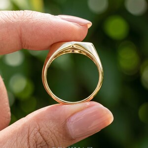 Signet ring gold side view showing the elongated geometric face, single round diamond and smooth tapered shoulders.