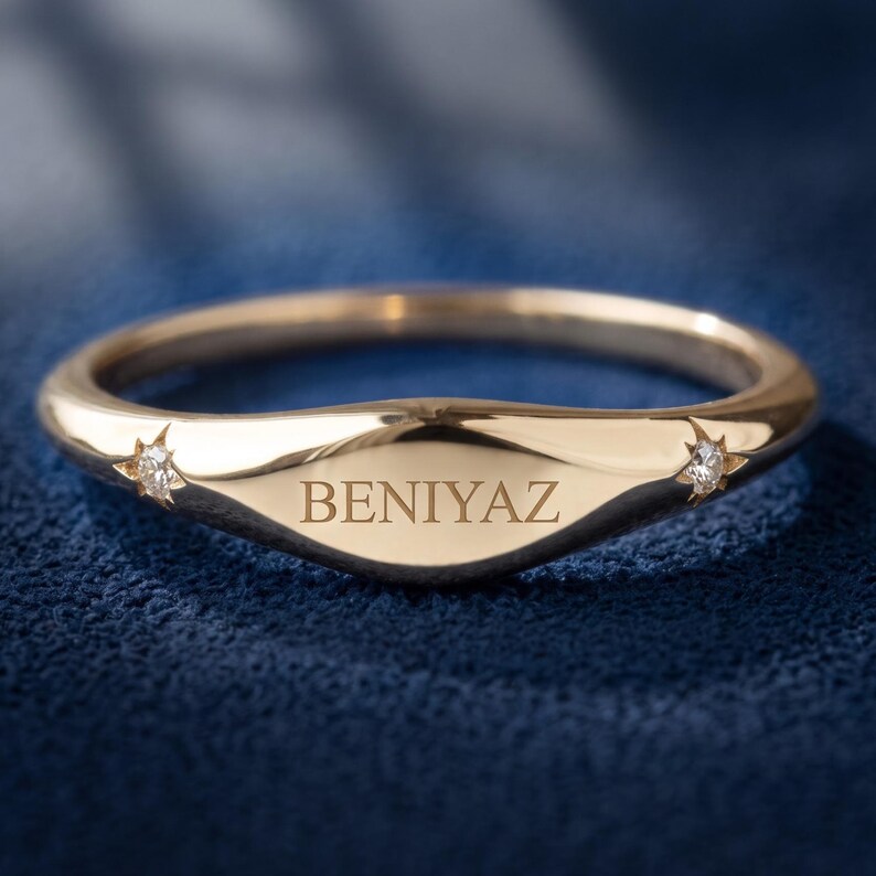 Personalized yellow gold signet ring engraved BENIYAZ with two small star-set lab grown diamond accents.