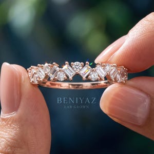 Hand displaying a 0.74 CT lab grown diamond band with baguette and round diamond accents, half eternity gold wedding ring with modern cluster design