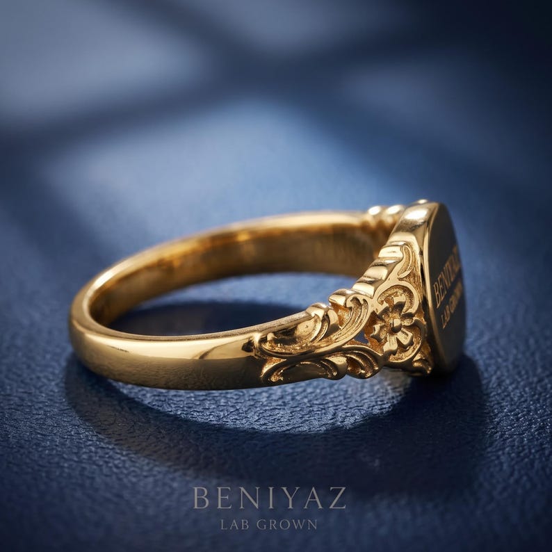 Side profile of a vintage floral oval signet ring showing the tapered shank and sculpted scrollwork shoulder details.