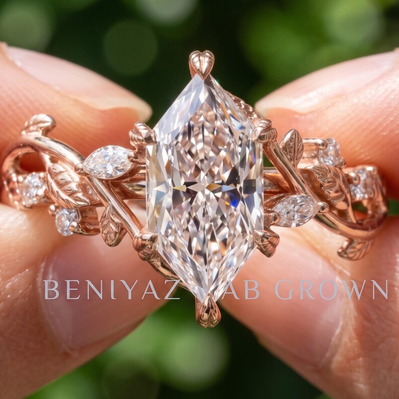 Hand holding a Dutch marquise lab grown diamond engagement ring in rose gold with twig and vine inspired branch details and a woodland style setting